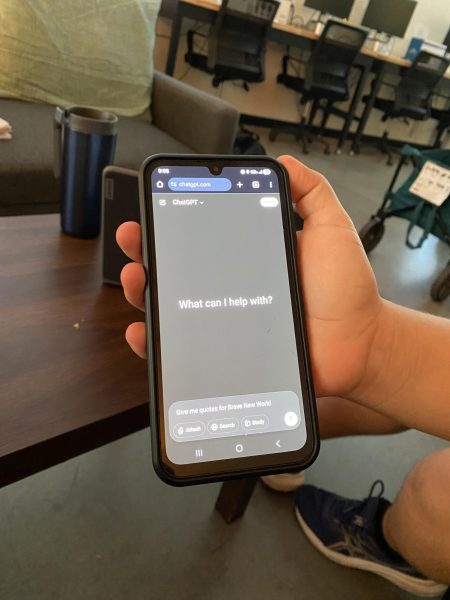 A student pulls up ChatGPT, a popular AI, on their phone. The website is blocked on student computers.
