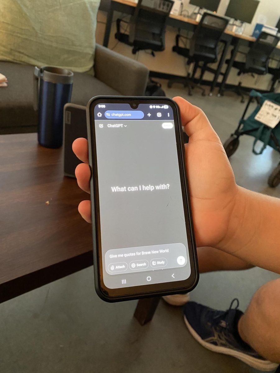 A student pulls up ChatGPT, a popular AI, on their phone. The website is blocked on student computers.